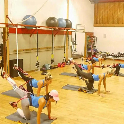 Women exercising with fitness resistance bands in a gym, emphasizing health and sports versatility.